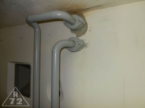 Chybami se člověk učí, takže jsme museli odříznout před lety slavně nainstalované příruby na dvojvýfuk, protože tady prostě neměly být. Tady se to mělo řešit jinak, tak jak vidíte na obrázku, tedy samosvorná uložení pomocí dvou přírub a navařených kroužků na trubky.<br>Zde tedy odparka a výfuk ze strojovny.<br>Jinak jak tu mohl někdo pozorovat stěnovým periskopem mezi těmi dvěma trubkami, když ta vpravo ještě musí být "oizolována" a bude tedy výrazně objemnější, to nám moc hlava nebere. Periskopová trubka tam jinak částečně vykukuje zpoza pravé trubky.<br>Podle všeho to vypadá, že kdyby se posunul prostup v podlaze více do týlu, vyjde to skvěle, ale asi trochu chybička ve stavbě. Našli jsme jich na objektu ostatně více.