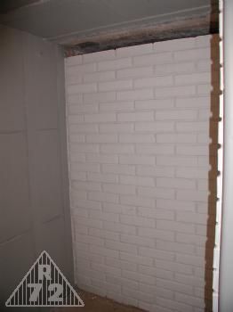 Vybílené příčky v místnosti stanoviště velitele.