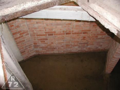 Pohled průlezem do týlového patra na dokončenou příčku oddělující minomet. Vpravo vstup do skladu munice pro minomet.