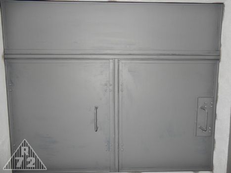 Detail třídílného poklopu průlezu do spodního patra objektu. Pohled zespoda.