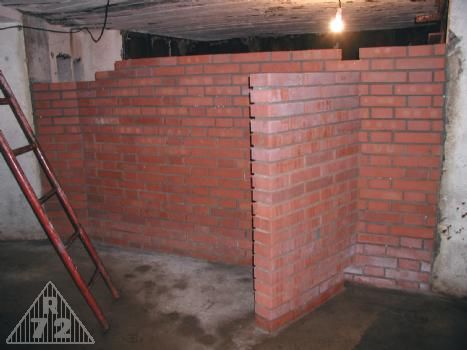 Takto vypadá téměř dokončená příčka oddělující místnost G od zbytku podzemí. Z příčky o síle 30cm vystupuje další o síle 15cm jako součást místnosti pro uskladnění munice pro G. <br>Vše co vidíte z cihel na obrázku původně neexistovalo, neboť po explozi v místnosti G (nejspíš trofejní munice) došlo ke zřícení celé této stěny právě do místnosti minometu.
