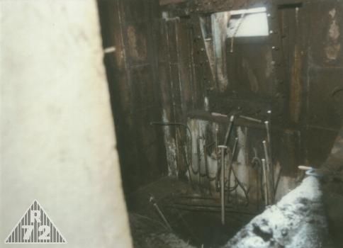 Místnost G ještě s původním armováním fundamentu pro zbraň G. Toto bylo silně poničeno díky explozi uvnitř místnosti, kdy vzala za své i 30 cm silná cihlová příčka jejíž základ jest viditelný v pravém dolním rohu. <br>Na snímku je dále vidět v jakém stavu se nachází samotná střílna G a její bezprostřední okolí. Troufám si tvrdit, že snad neznám střílnu v horším stavu co se týče koroze.