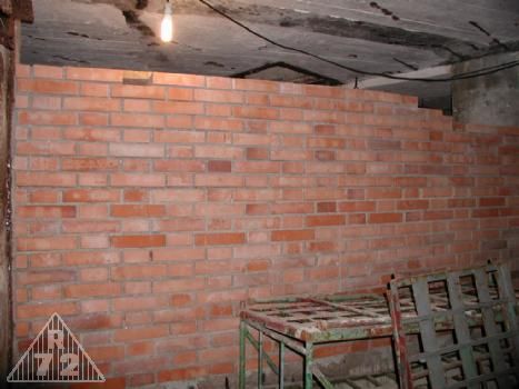 Stěna oddělující místnost minometu od prostoru průlezu.