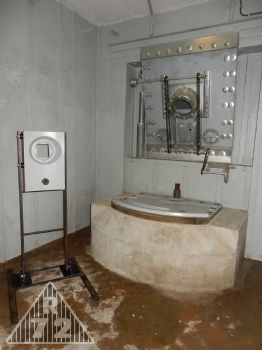 Osazená krycí deska střílny minometu včetně pancéřové oponky, fundament na minomet a na něm jediná část zbraně, která se do dnešních dnů zachovala - spodní část lafety. <br>Vlevo pak instalace makety střílny zvonu do které se následně osadí maketa 5cm minometu.