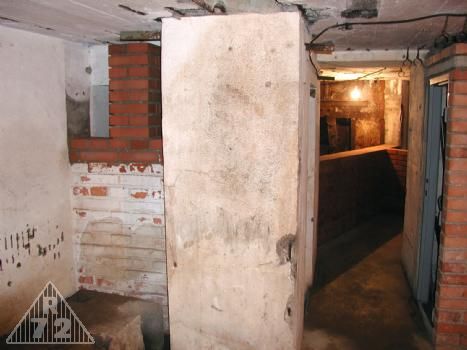 Pohled ze strojovny. V levém dolním rohu fundament pro filtry, nad ním prostupy ve zdi do místnosti G. Pravo pak místnost pro sklad proviantu a vzadu vznikající příčka u minometu.