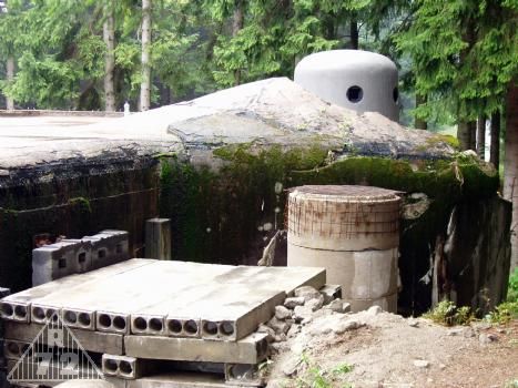 Dokončený pancéřový zvon, prefabrikáty nahrazující zničenou revizní šachtu a budoucí zához.