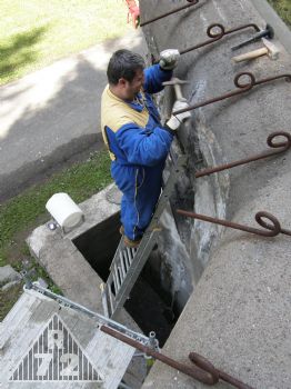 Odsekávání zvětralé a jinak poškozené omítky krakorce pravé kasematy.