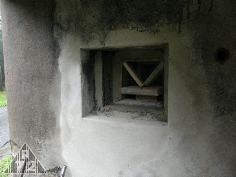 Oprava poničené střílny lehkého kulometu vlevo od vchodu.