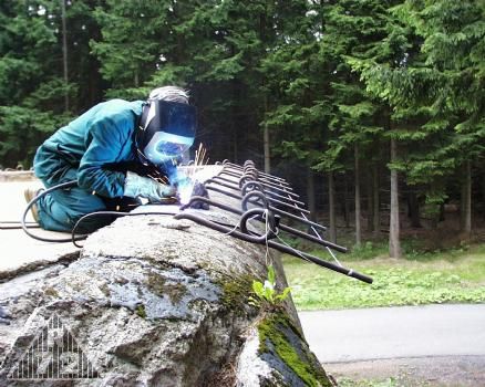 Přivařování odřezaných háků na maskovací sítě.
