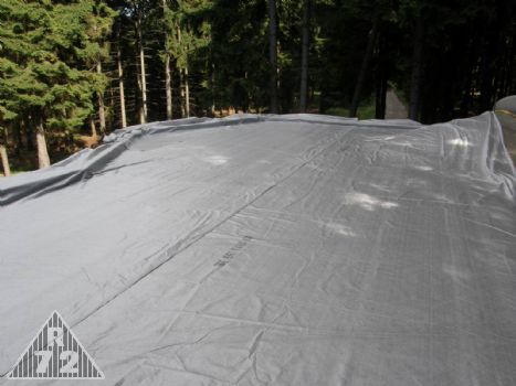 Uložení geotextilie na hotový zaizolovaný strop. Na tuto látku následně přijde položit štěrkový koberec a následně zemina.