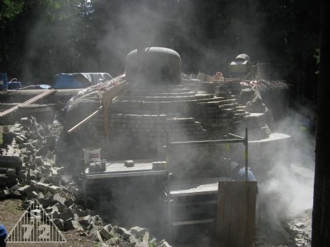 Do toho se válčilo dole s taktéž zmníněnými bloky betonu, jenž se vylomily po trhání zvonu. Jelikož značně přesahovaly obrys objektu a nepřekryl by je ani zához, musely pryč... V tuto chvíli probíhá jejich nařezávání flexou, aby šly lépe sbíjet. Bez toho nařezání to byla přímo Sysifovská práce.<br>
Ovšem řezat znamenalo ponořit se do oblaků prachu, jenž jsou na snímku více než zřetelné.