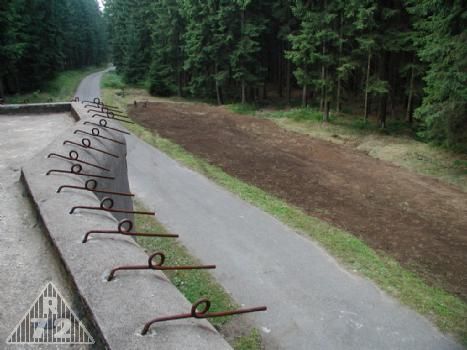 Vyrovnaný terén před objektem až po obvodovou překážku. Pohled k R-S 71.