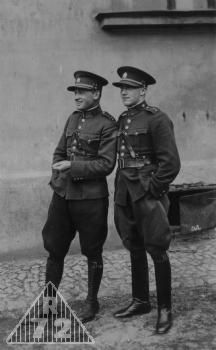 Dva poručíci pěchoty ve služebních stejnokrojích 1930-39. Je možno porovnat detaily blůz, jako např. manžetové knoflíky a tvar patek kapes. Oba mají čepice s výrazným štítkem. Důstojník vlevo má obuty nestandartní boty tzv. kanadky.
