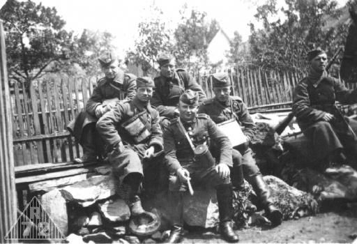 Cvičení jízdního útvaru. V popředí v polní čapce rotmistr ve stejnokroji do roku 1936 se starším typem plynové masky. Voják vedle něj má zajímavě umístěn mapník pod řemením.