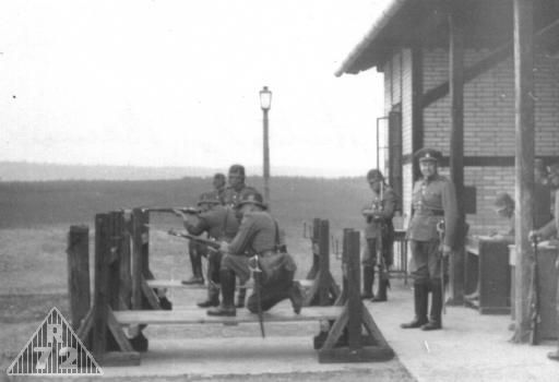 Výcvik ve střelbě. Stolice znesnadňuje zamíření. Předzvěst moderního taktického výcviku.